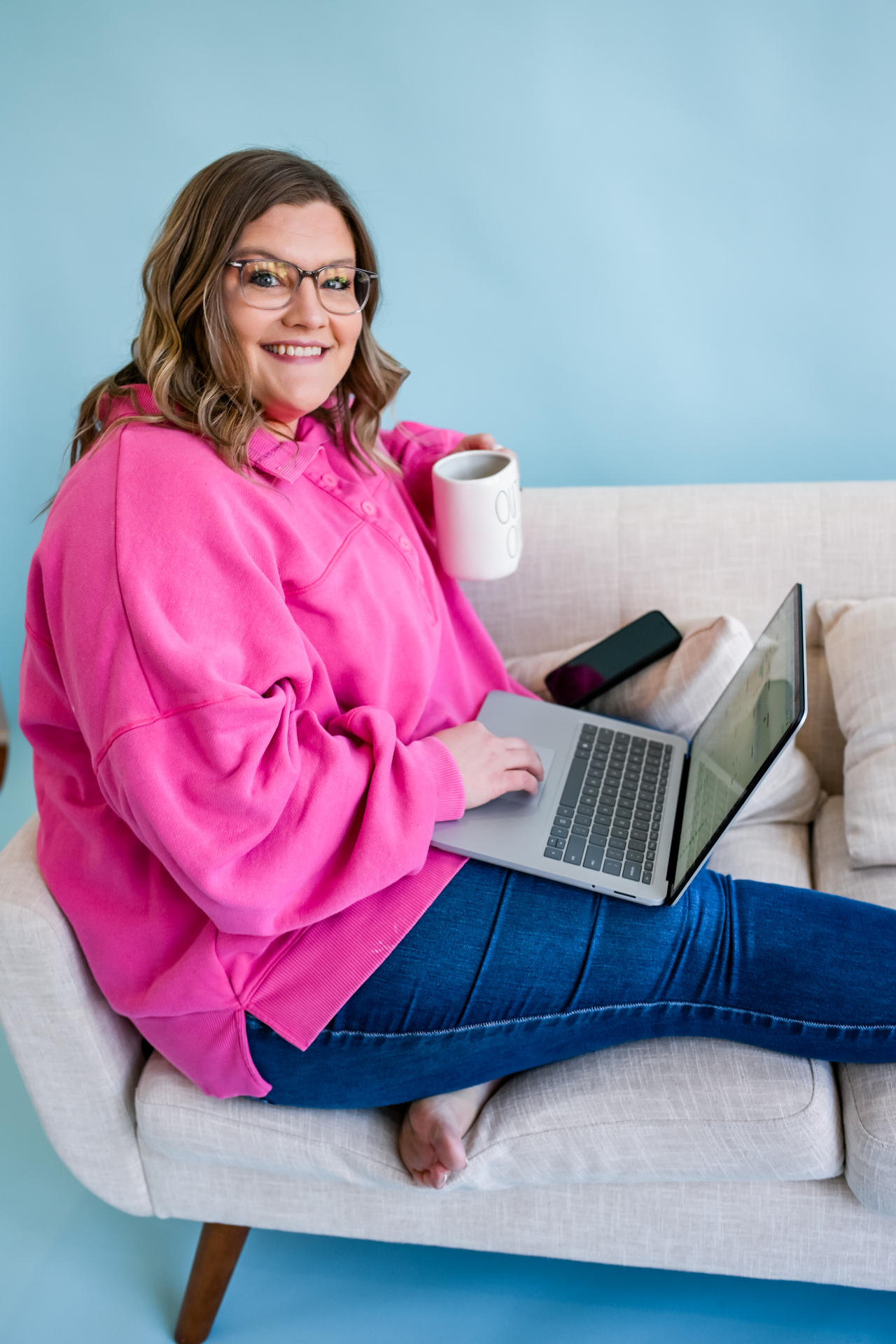 Shelb with her laptop and coffee on the couch
